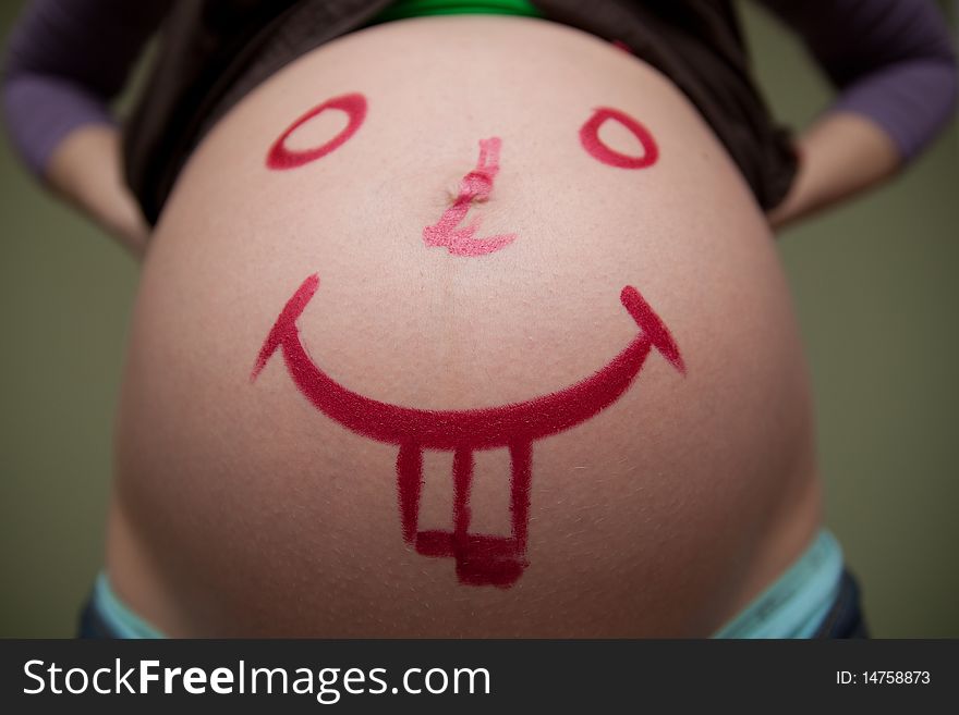 Pregnant belly with painted smile. Pregnant belly with painted smile