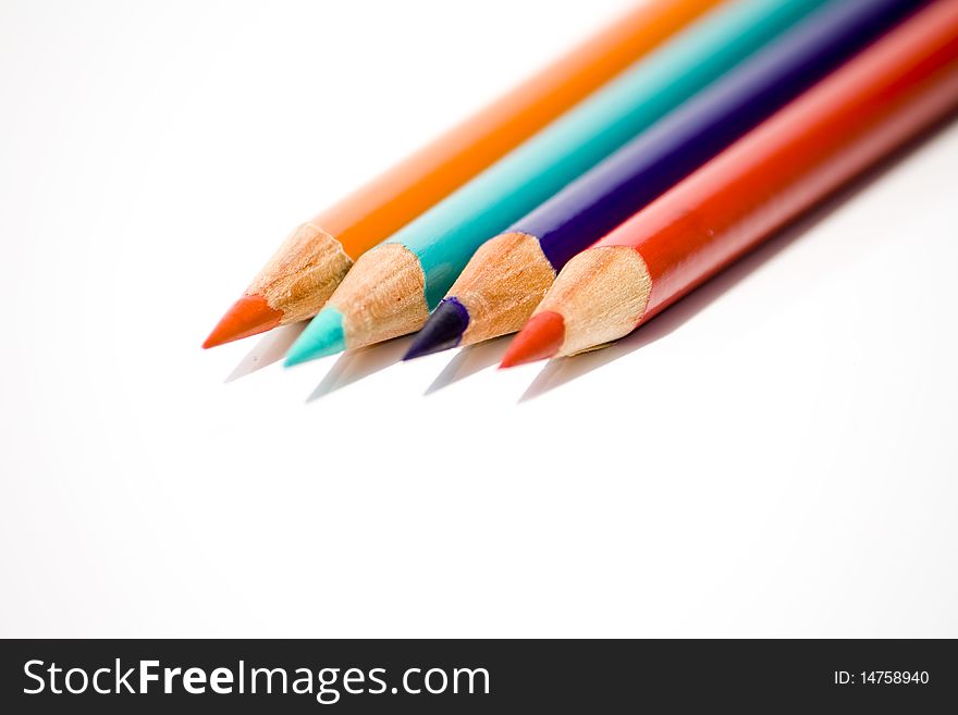 Four colored crayon red, orange, blue and light blue side by side on white background. Four colored crayon red, orange, blue and light blue side by side on white background