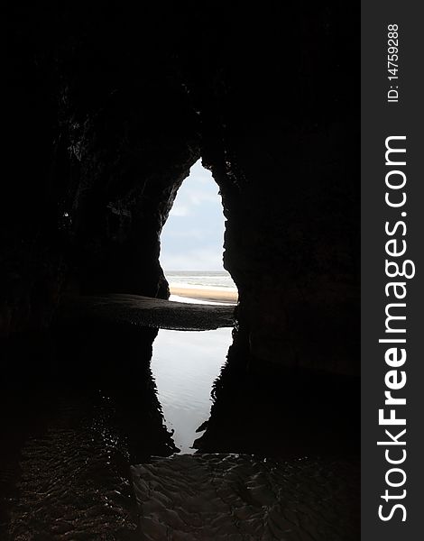 A view from the inside of a beach cave looking out at the sea. A view from the inside of a beach cave looking out at the sea