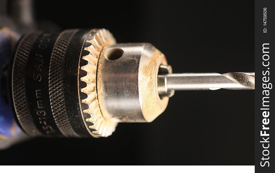Closeup of the chuck of a power drill with bit.