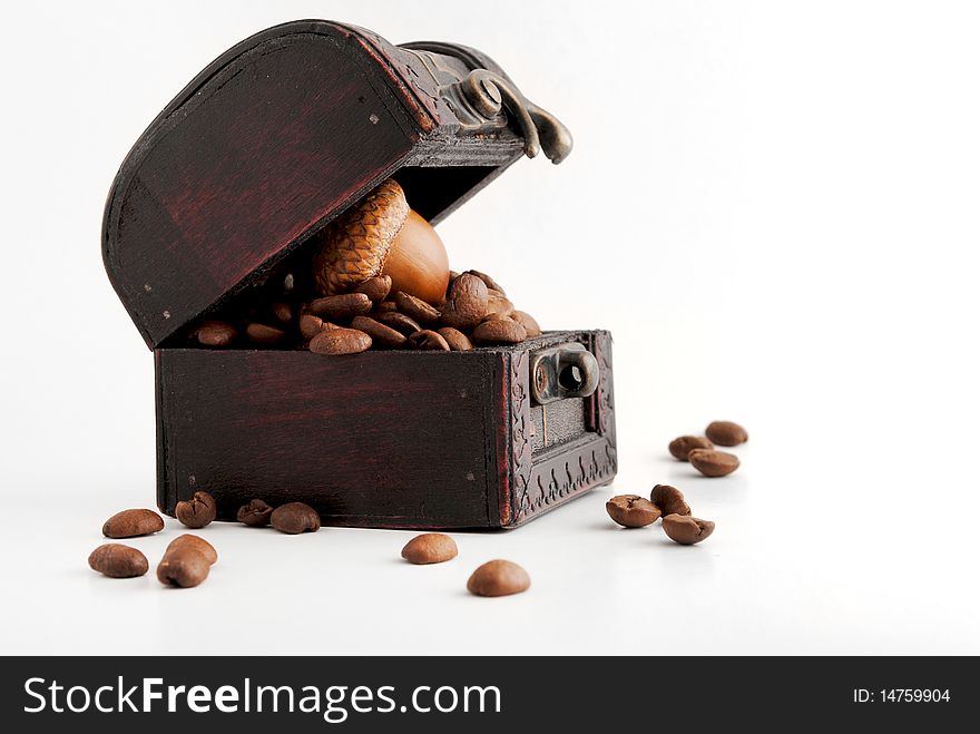 Coffe beans in a chest with an oversized oak nut on top. Coffe beans in a chest with an oversized oak nut on top