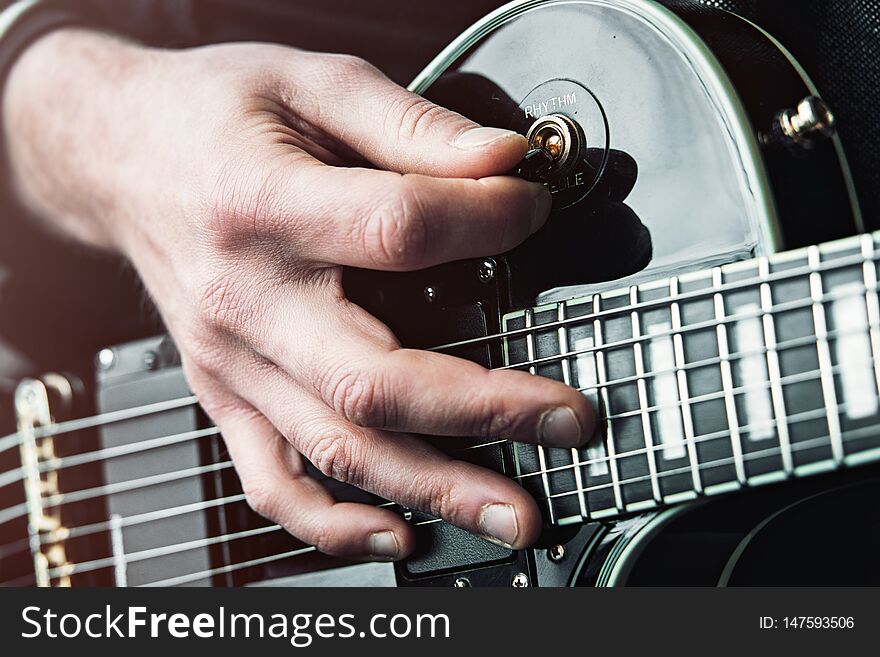 Close up shot of Hands of man playing electric guitar.