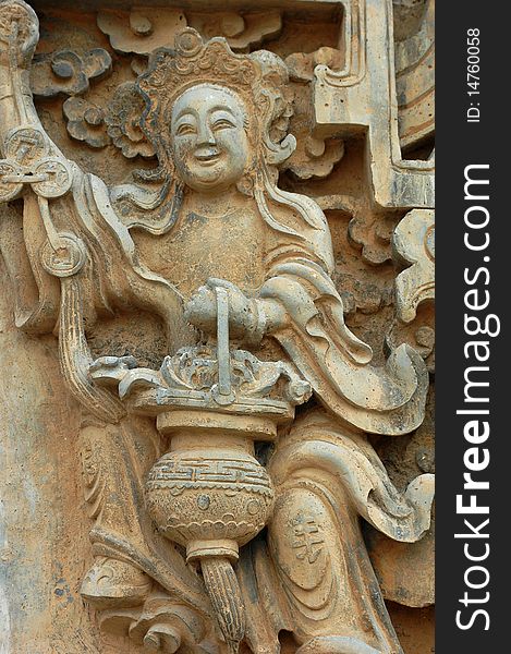 Stone sculpture of a smiling buddha holding a lantern