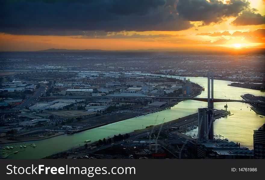 Sunsetting over a city, with a bridge featuring. Sunsetting over a city, with a bridge featuring