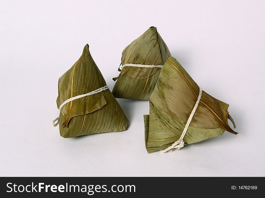 A pyramid-shaped mass of glutinous rice wrapped in leaves. A pyramid-shaped mass of glutinous rice wrapped in leaves
