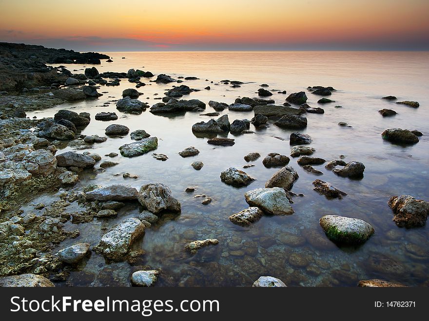 Sea and rock at the sunset. Nature composition.