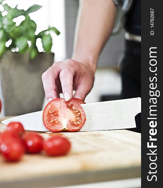 Close up of human cutting tomatoes