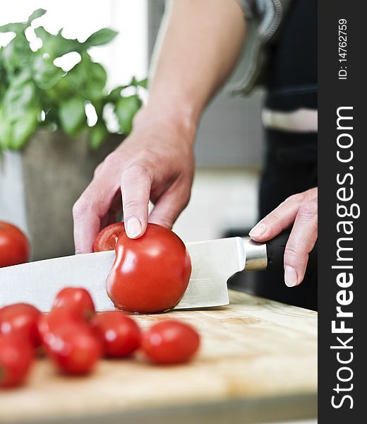 Close up of human cutting tomatoes