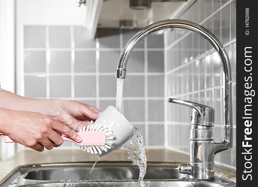Close up of a human washing a coffee cup