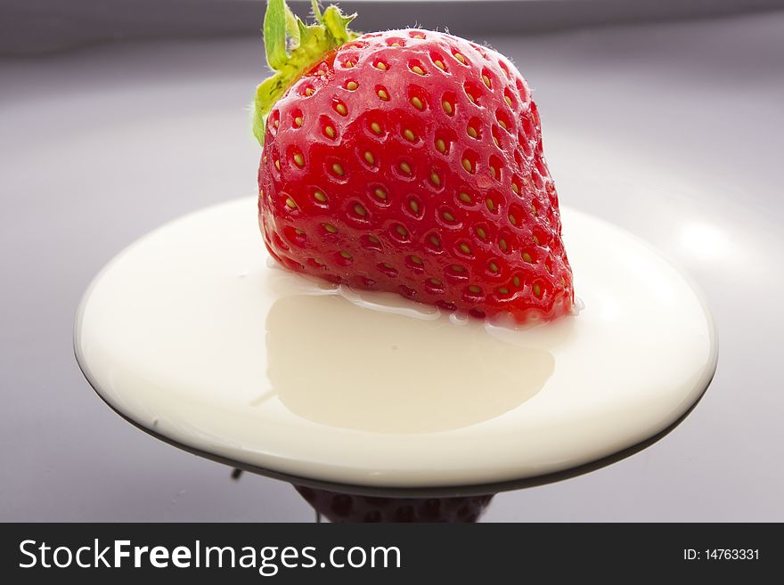 Red strawberry on black plate close-up