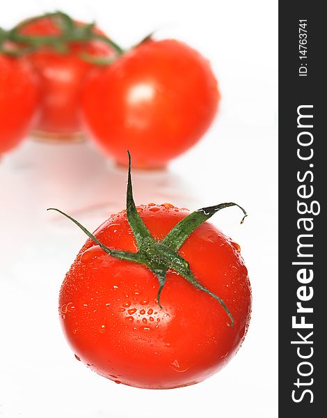 Fresh tomatoes with water drops on white background