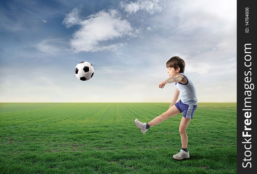 Child kicking a ball on a green meadow. Child kicking a ball on a green meadow
