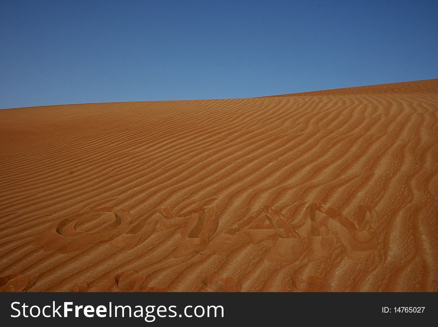 The word OMAN written in the desert sand