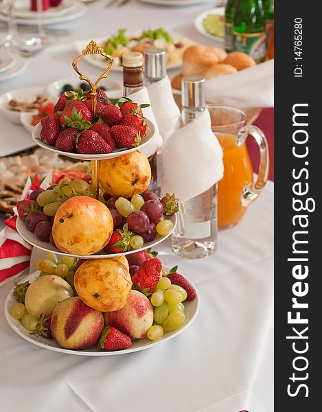 On a celebratory table in a vase fruit and berries for a dessert. On a celebratory table in a vase fruit and berries for a dessert.