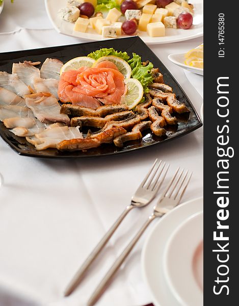 Slices of fish delicacies are spread out on a plate. Slices of fish delicacies are spread out on a plate.