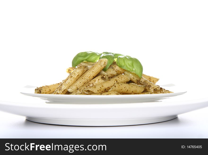 Penne with pesto decorated with basil on a plate