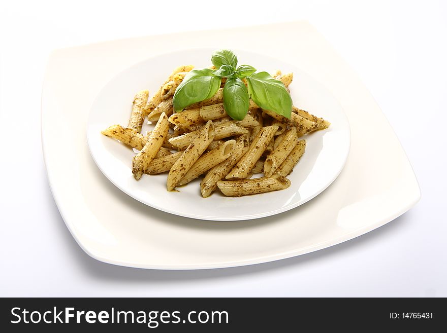 Penne with pesto decorated with basil on a plate