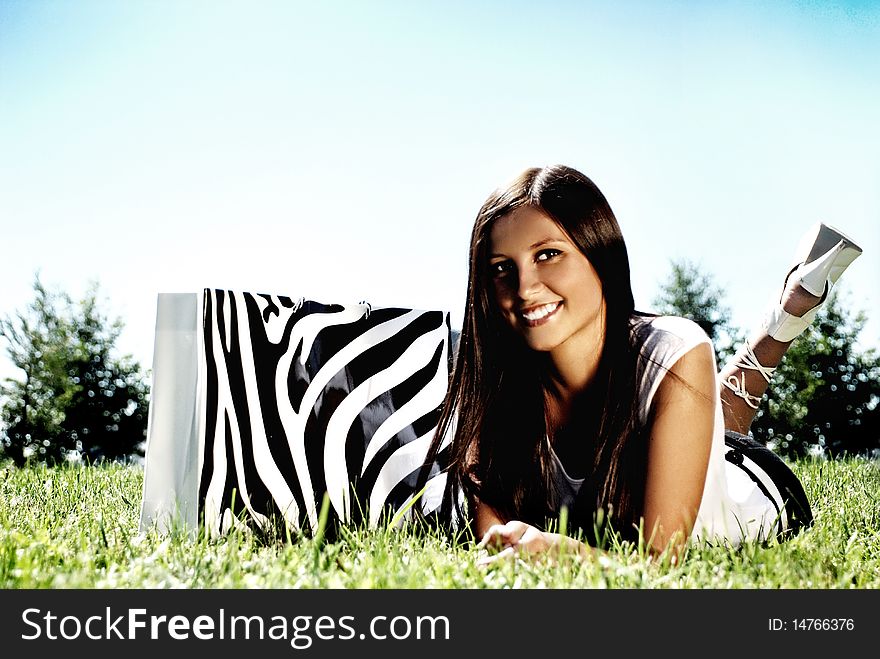 Fashion Model With Bag On A Grass.