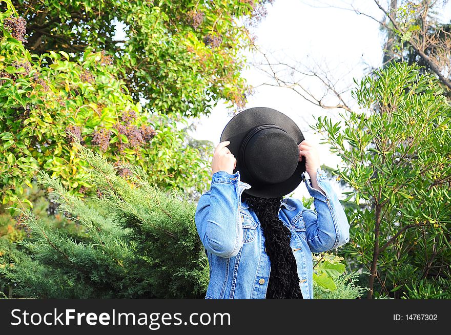 A woman wears black felt hat