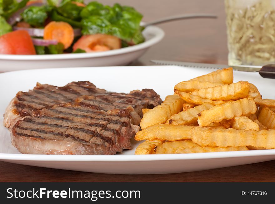 Rib eye steak meal with french fries, salad and drink. Rib eye steak meal with french fries, salad and drink