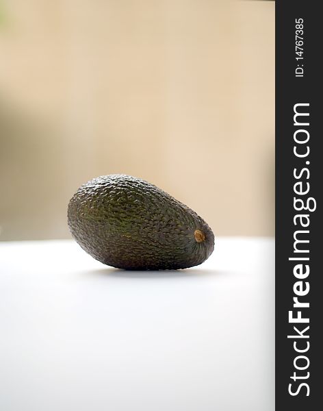 A Hass variety avocado bathed in natural light - shallow depth of field in portrait orientation. A Hass variety avocado bathed in natural light - shallow depth of field in portrait orientation