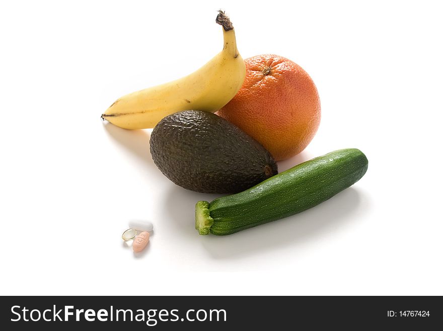 A variety of fresh fruits and vegetables with some vitamin tablets. A variety of fresh fruits and vegetables with some vitamin tablets