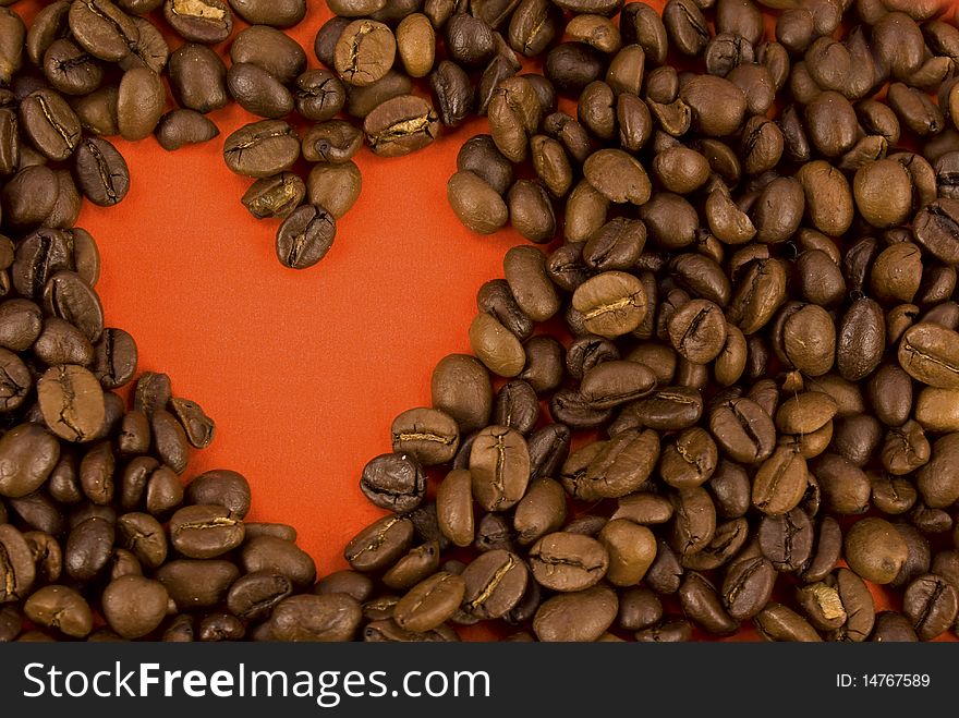 Creative photo of coffee beans making up form of heart of red color