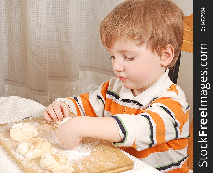 Little cute boy making buns