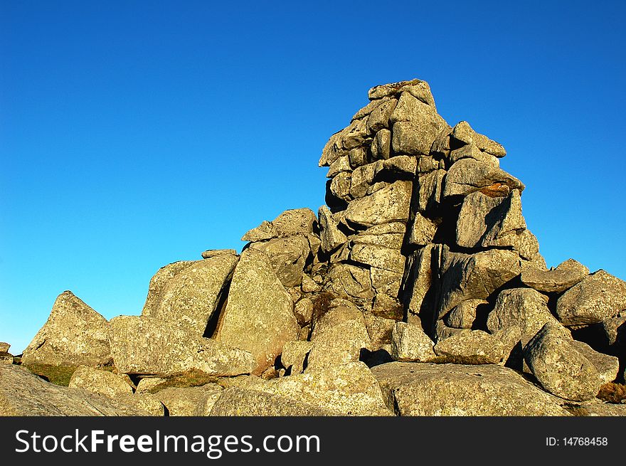 Scenery of huge rocks at the top of mountains with blue skies as backgrounds