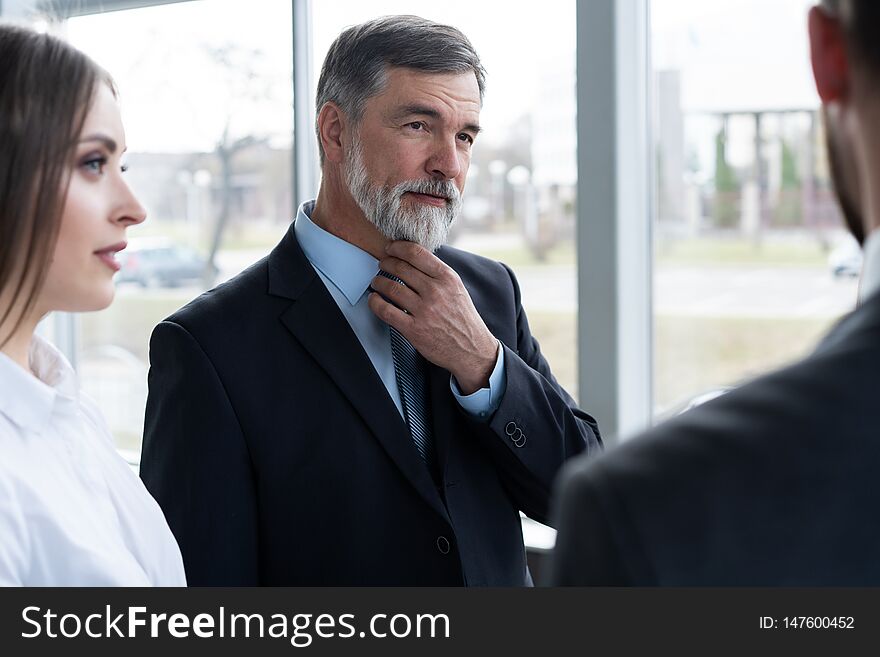 Group Of Busy Business People Concept. Business Team Discussing Work In Office Building Hallway.