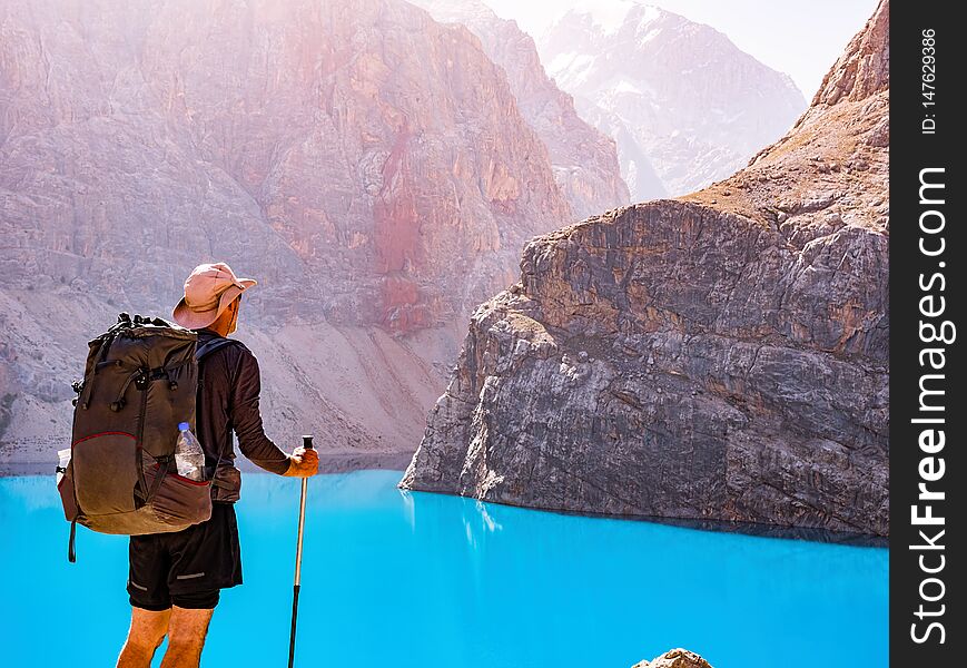 Man With Backpack Near Lake Big Alo On Rocky Mountain Background