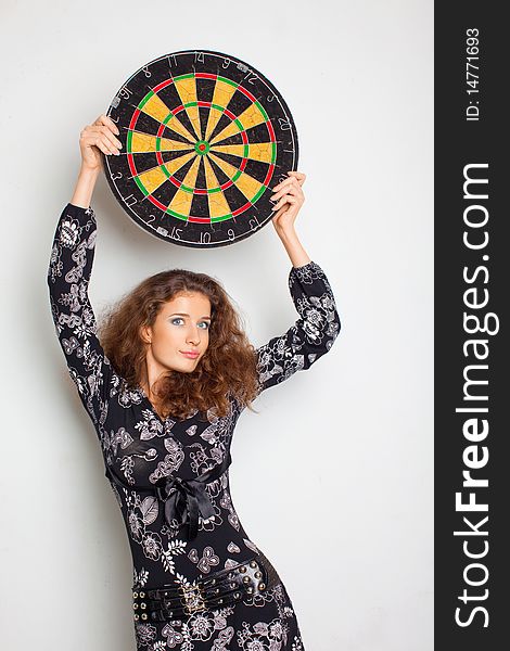 Beautiful girl in black dress with darts on the white background