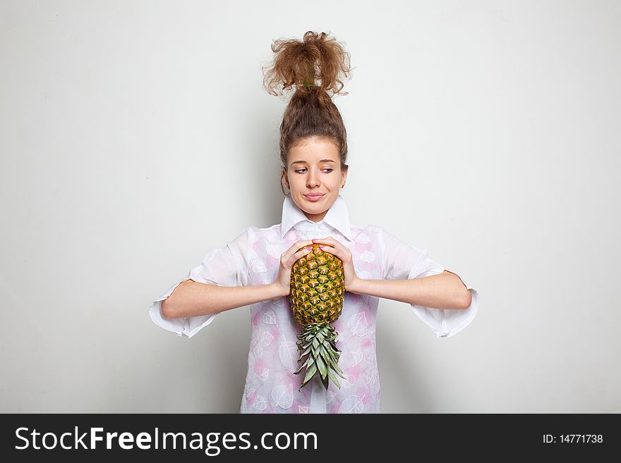 Young pretty girl with a pineapple in her hands