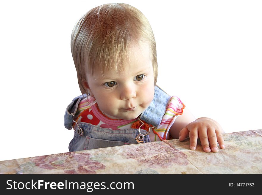 The child sitting at a table on a wooden chair has reflected. The child sitting at a table on a wooden chair has reflected