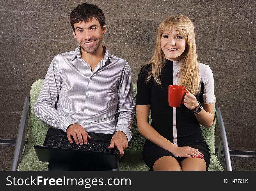 Young man and woman sitting with a laptop indoors