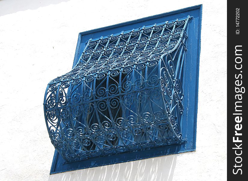 Typical window closed with wrought iron painted in blue in the village of Sidi Bou Said in Tunisia