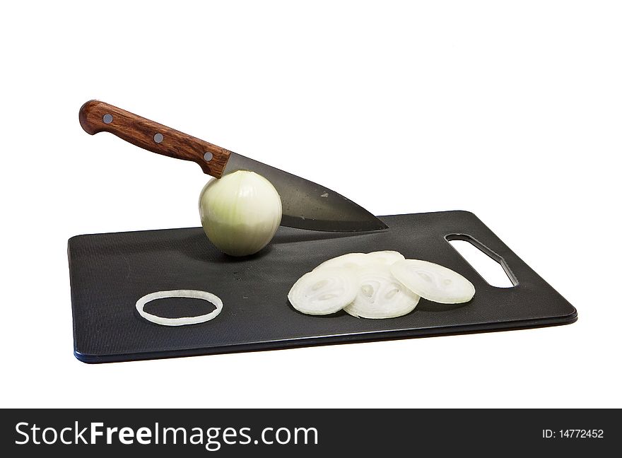 Cut onion and kitchen knife on black chopping board. Cut onion and kitchen knife on black chopping board