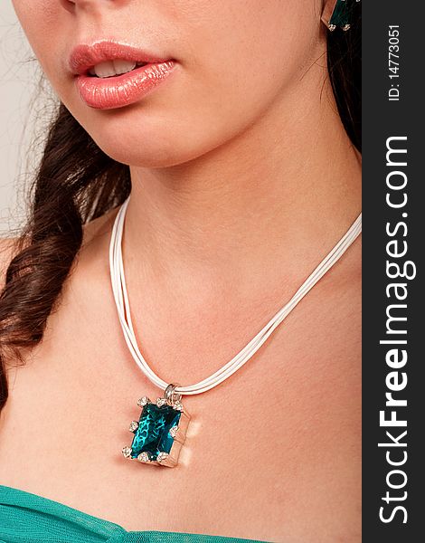 Beautiful young lady shows necklace with big blue gem. Beautiful young lady shows necklace with big blue gem