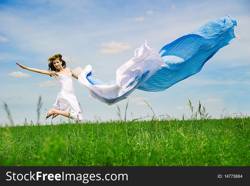 Happy young woman jumps. Sky as background