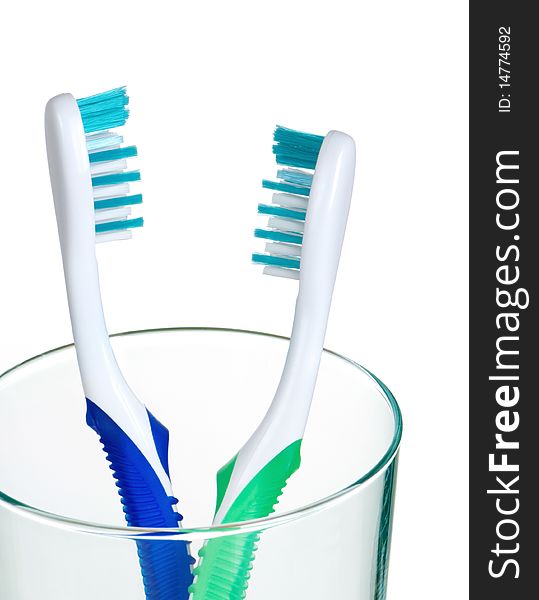 Two new clean toothbrushes in a drinking glass. Two new clean toothbrushes in a drinking glass