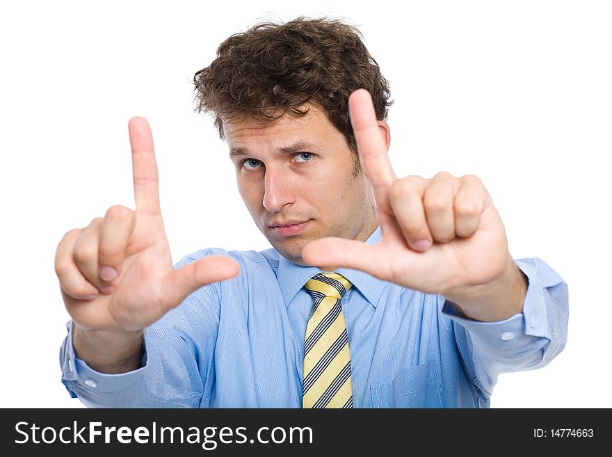 Young photographer trying to compose a frame for photograph using his hands, studio shoot isolated on white background