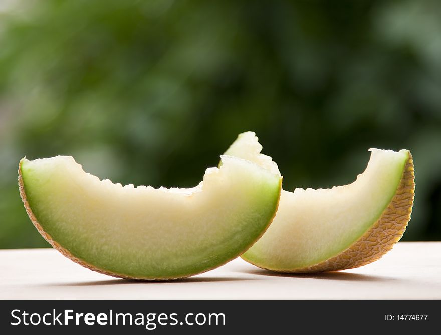 Melon slices against green background