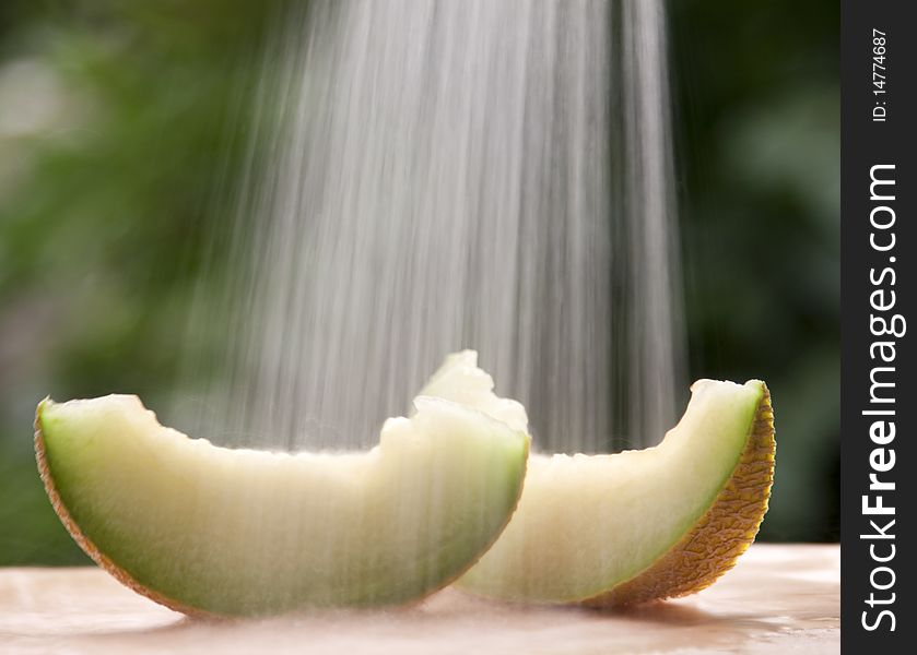 Melon slices under flowing water