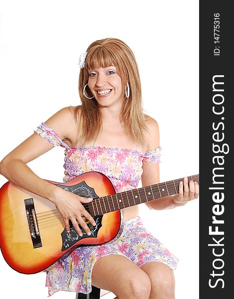 A beautiful woman sitting and playing the guitar in a light colorful short 
top and skirt, for white background. A beautiful woman sitting and playing the guitar in a light colorful short 
top and skirt, for white background.
