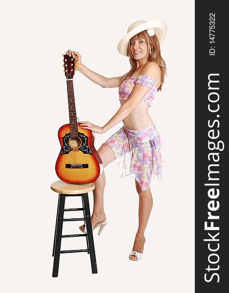 A beautiful woman standing and holding the guitar in a light colorful short top and skirt and beige straw hat, for white background. A beautiful woman standing and holding the guitar in a light colorful short top and skirt and beige straw hat, for white background.