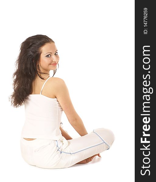 A young and happy brunette is sitting on the floor. The image is isolated on a white background. A young and happy brunette is sitting on the floor. The image is isolated on a white background.