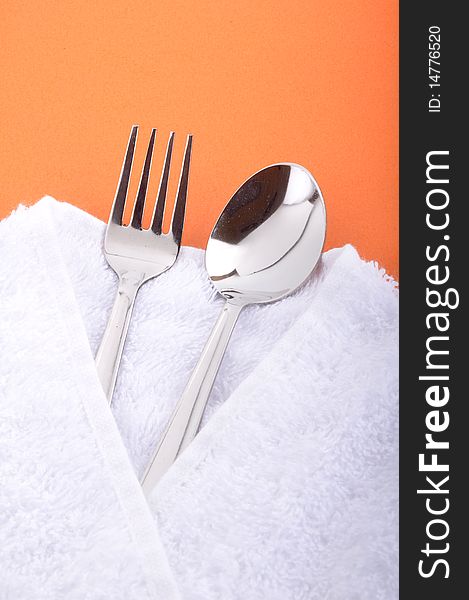 Place setting fork and spoon on orange background