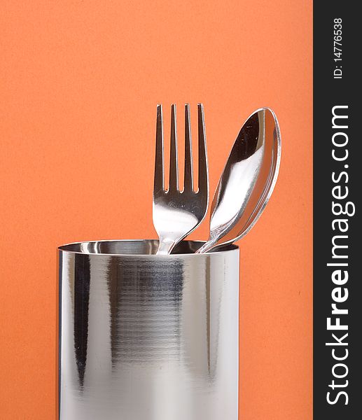 Place setting fork and spoon on orange background