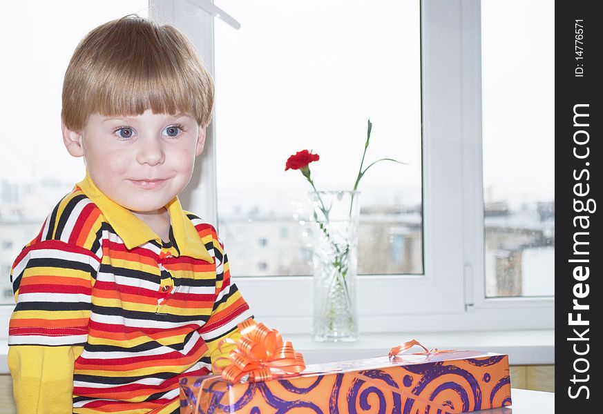 Portrait of the little boy with a gift box on a background. Portrait of the little boy with a gift box on a background