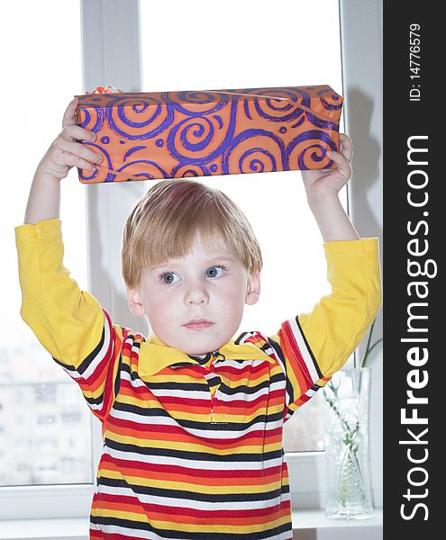 Portrait of the little boy with a gift box on a background. Portrait of the little boy with a gift box on a background